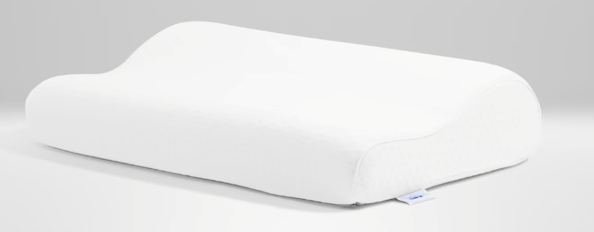 An orthopedic cervical pillow shown on a bed, designed to support proper neck alignment during sleep, reduce jaw muscle tension, and minimize nighttime clenching.