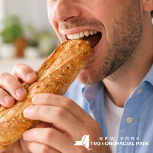 Man biting into a crusty baguette that may contribute to TMJ strain